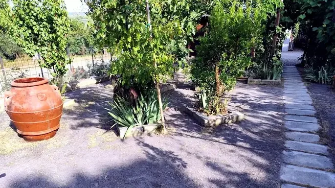 Il giardino al giorno 0: terra nuda dopo la scalpatura, con l'orcio di terracotta