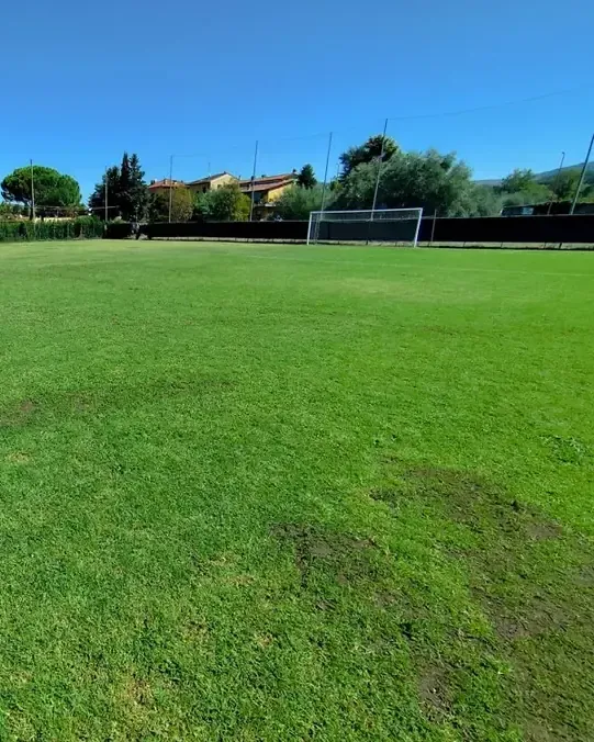 Campo da calcio a 11 con la porta sullo sfondo, in una giornata di sole