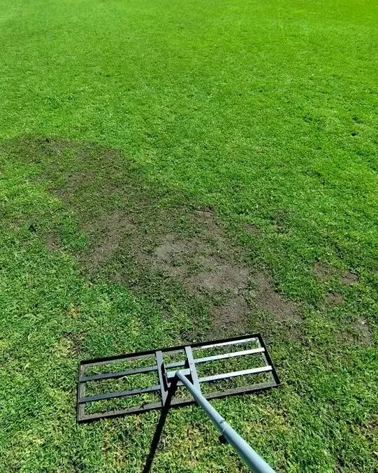 Livellatore appoggiato su una zona d'erba consumata del campo