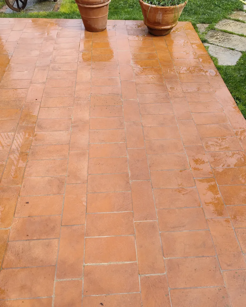 Terrazzo in cotto bagnato, con due vasi di terracotta in fondo